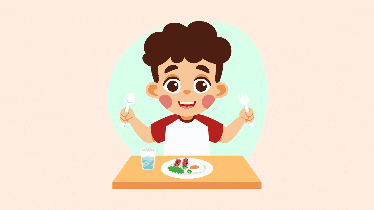 Cartoon of a young boy sat at a table set with a plate of food and glass of water. He is holding a knife and fork in the air and is smiling.